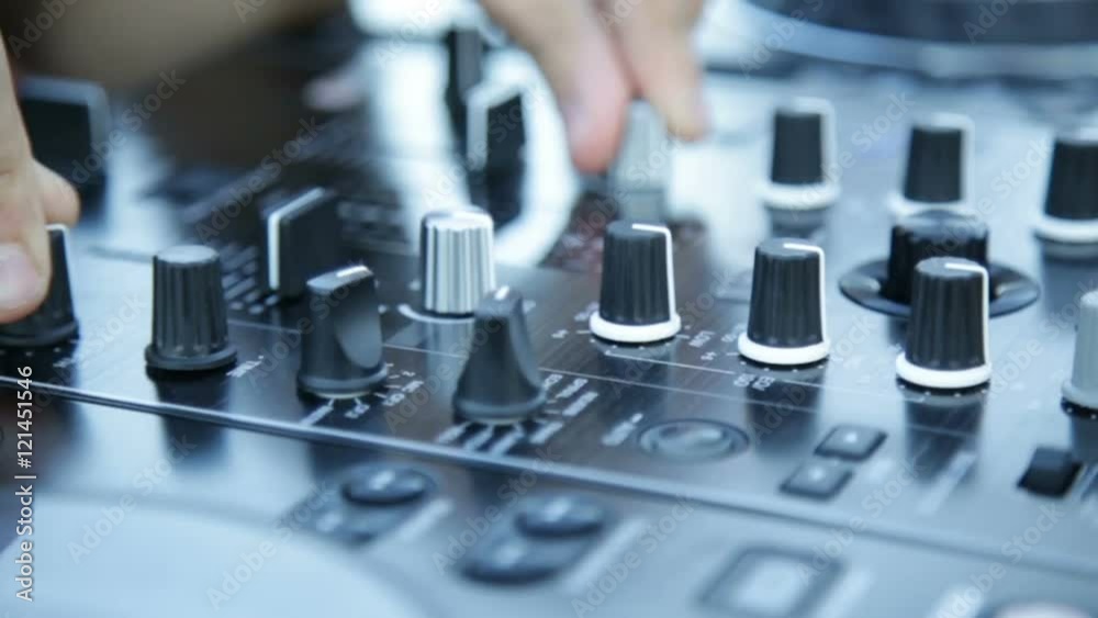 Mani del deejay sul mixer alzano volume durante una festa diurna in discoteca all'aperto. Mani del deejay sul mixer alzano volume durante una festa diurna in discoteca all'aperto.