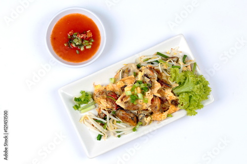 Fried oyster with bean sprouts and shallot as "Hoi Tod" in Thai served with chili sauce.Top View