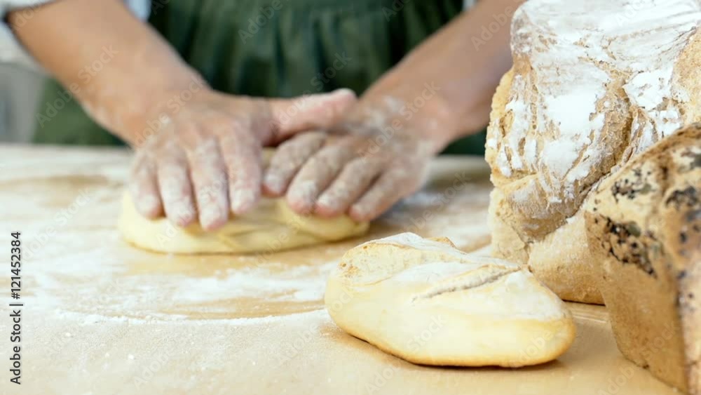 Woman kneading the dough and making a ball of it on the wooden table, dolly shot
Woman kneading the dough and making a ball of it on the wooden table, dolly shot