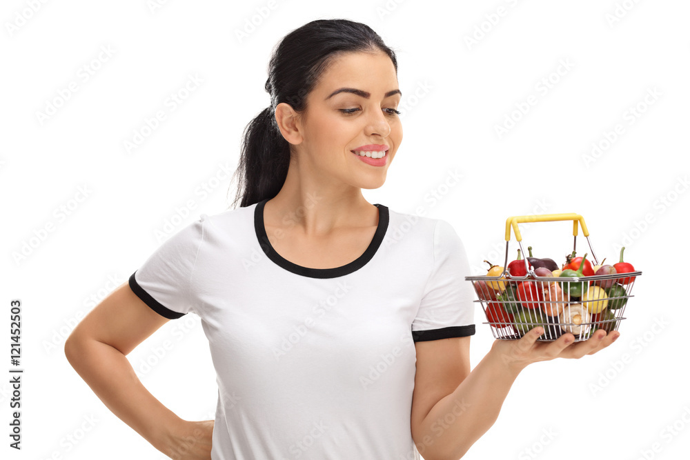 Young woman looking at a small shopping basket Young woman looking at a small shopping basket