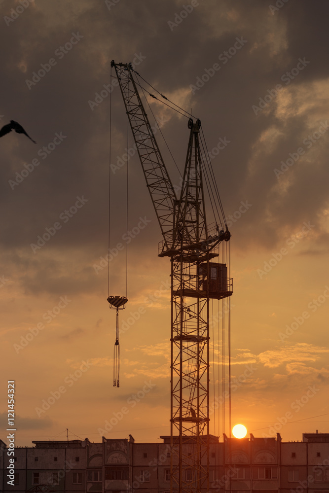 Silhouette of the tower crane on the construction site with city building background