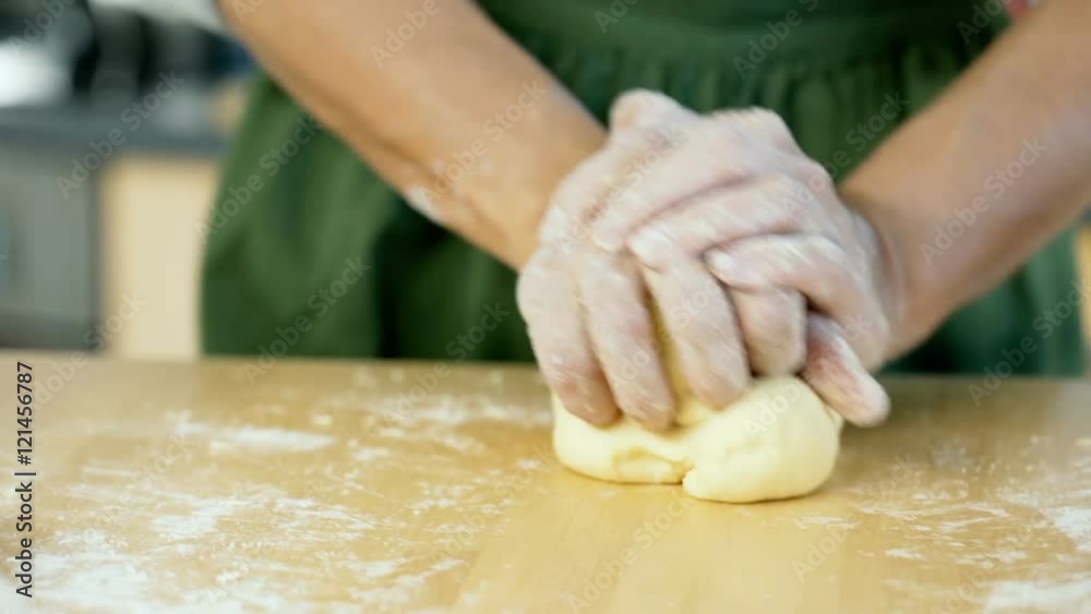 View of the fresh basil and woman kneading the dough on the wooden table, dolly shot
View of the fresh basil and woman kneading the dough on the wooden table, dolly shot