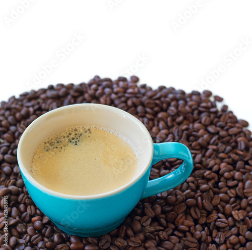 Delicious fresh cup of coffee on beans isolated on white