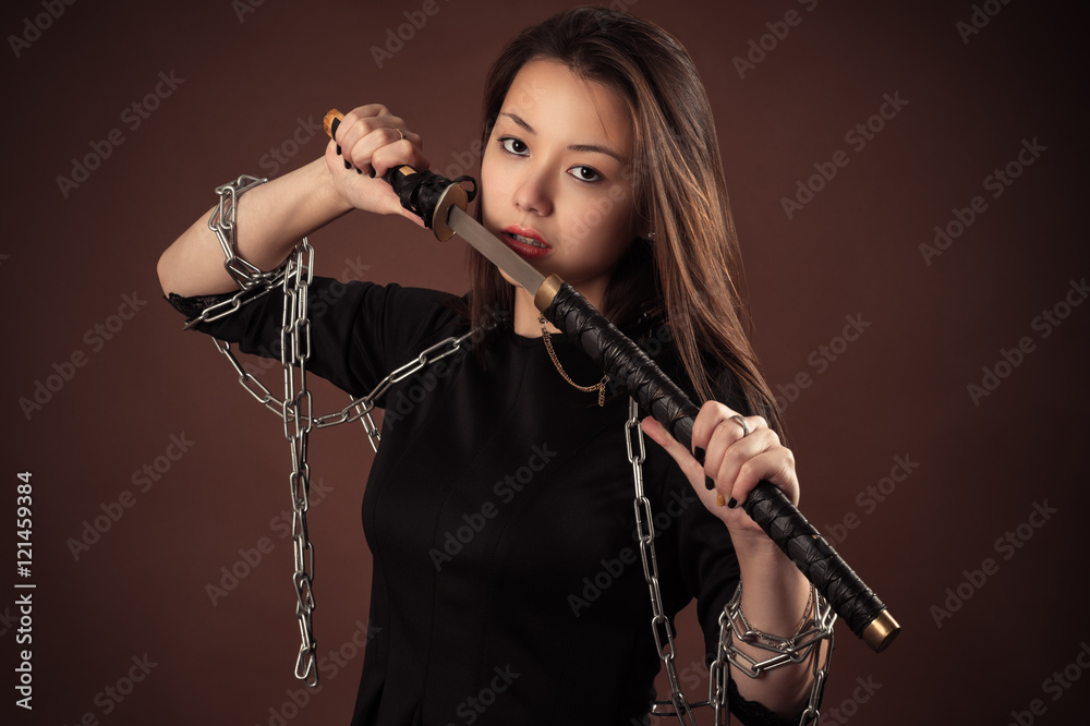 brutal korean girl with sword isolated on brown background