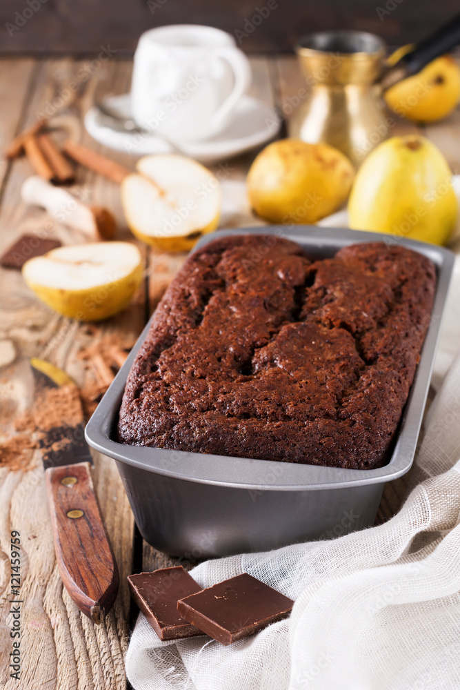 .Chocolate cake with pears and cinnamon on old wooden background. Selective focus. .Chocolate cake with pears and cinnamon on old wooden background. Selective focus.