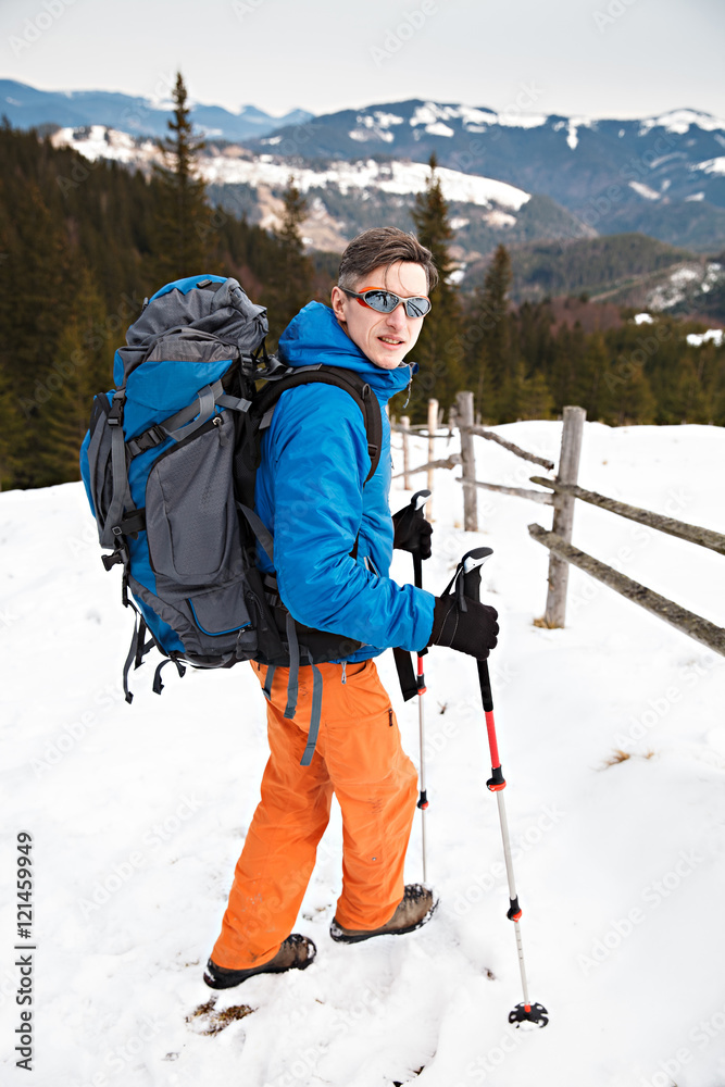 Hiker with huge backpack in winter mountains