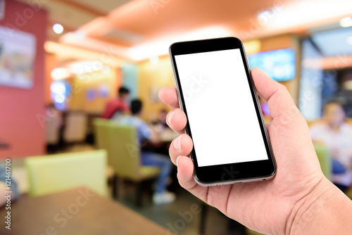 hand holding the phone tablet on blur restaurant background,Transactions by smartphone concept