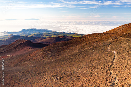 Inspirational landscape with woman running on mountain trail, Canary Islands view.