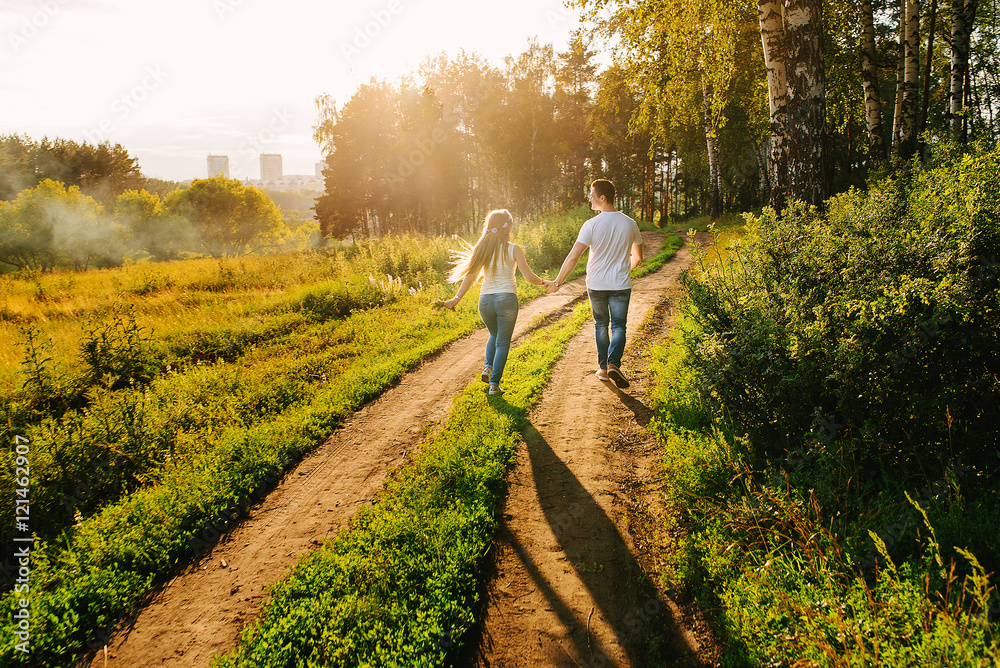 A happy couple walking together in a green countryside