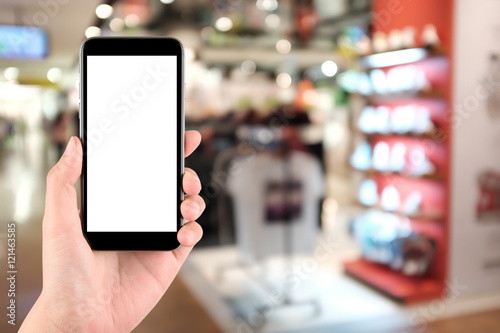 Smart phone with white screen in hand on blurred in shopping mall background,shopping online concept,shopping by smart phone