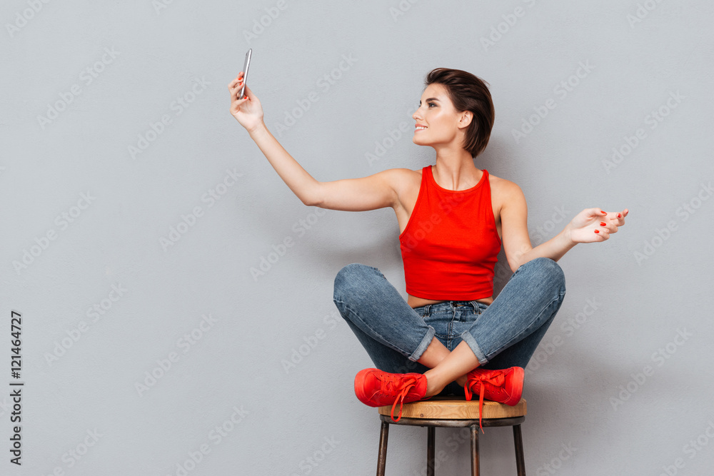 Smiling young woman making selfie photo on smartphone Smiling young woman making selfie photo on smartphone