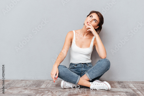 Casual happy wondering woman sitting on the floor © Drobot Dean