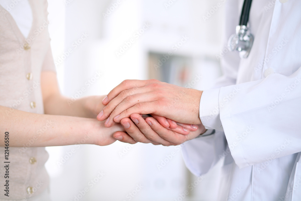 Hand of doctor reassuring her female patient