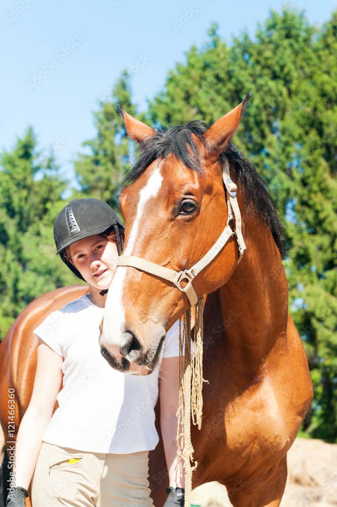 Young teenage girl equestrian standing with her brown horse Young teenage girl equestrian standing with her brown horse