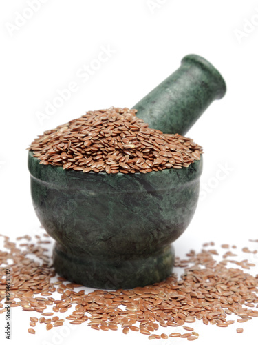 Organic Indian Linseed (Linum usitatissimum) on marble pestle and over white background photo