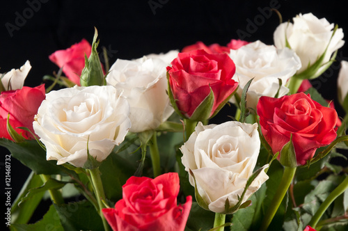 White and red roses on black background