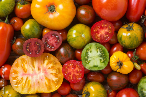 Fotografie, Obraz Close up of colorful tomatoes, some sliced, shot from above