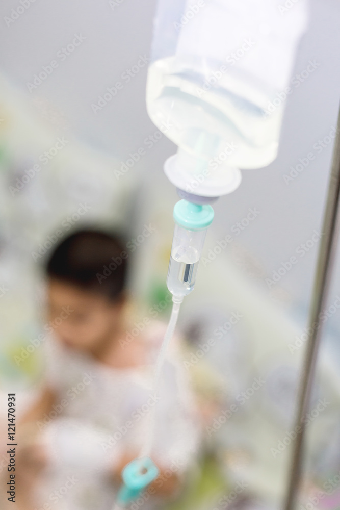 saline solution IV with blurred asian boy in hospital room saline solution IV with blurred asian boy in hospital room