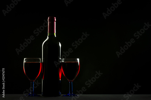 Glasses and bottle of wine isolated on a black background
