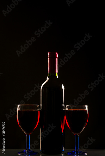 Glasses and bottle of wine isolated on a black background