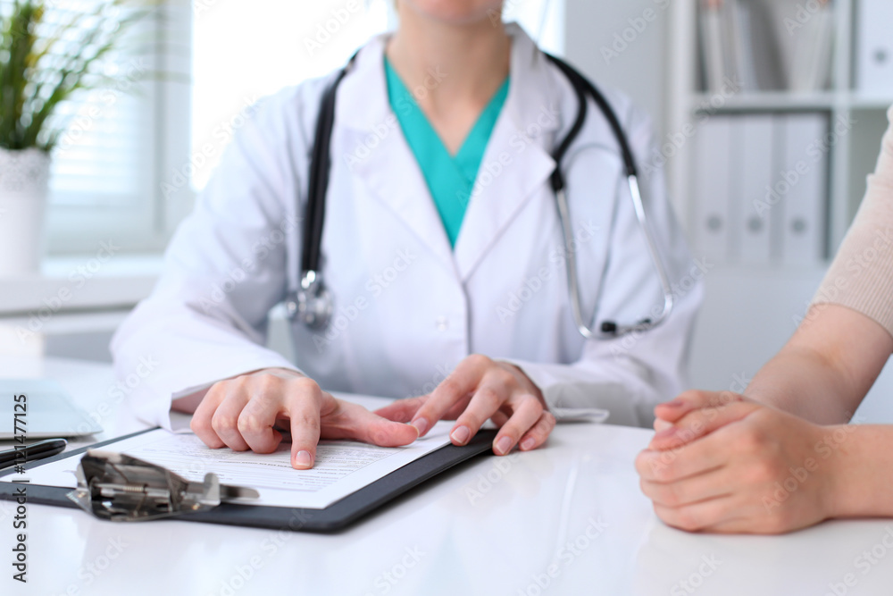 Doctor and patient are discussing something, just hands at the table Doctor and patient are discussing something, just hands at the table