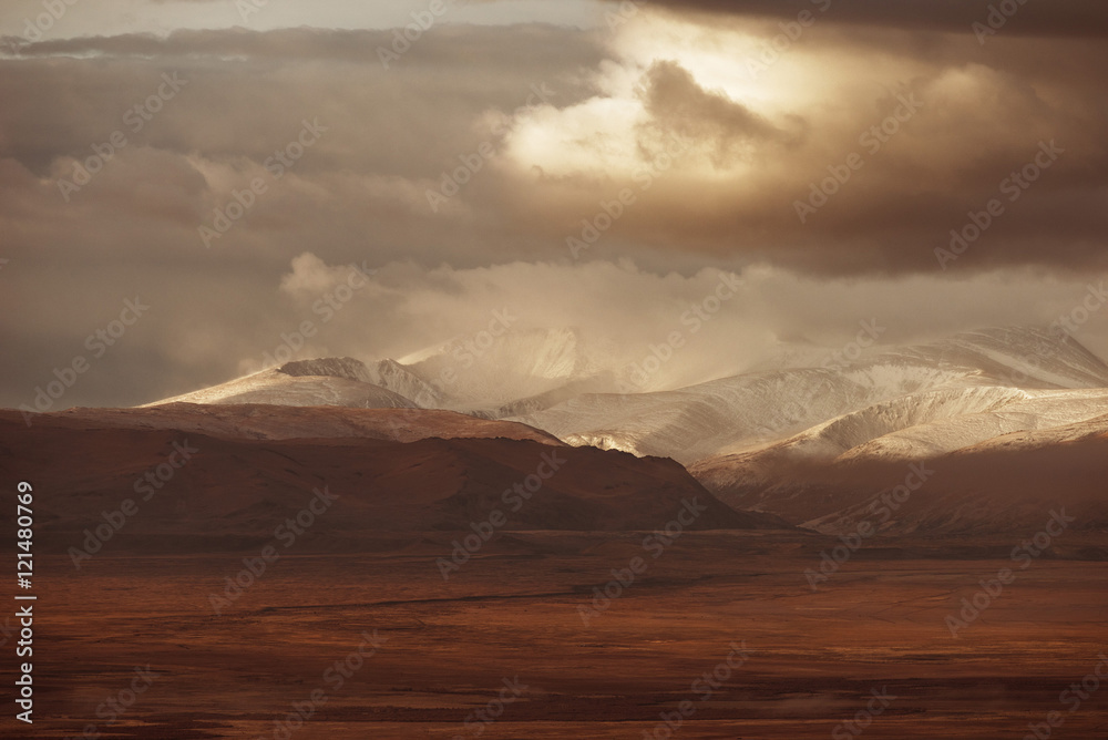 Mountain valley on the dark cloudy sky background. Altay