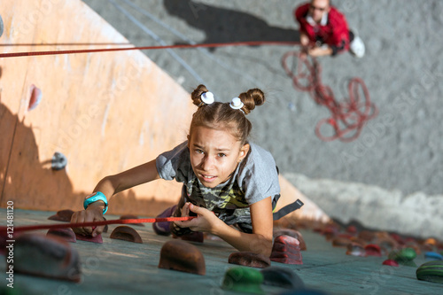 Εκτύπωση καμβά Little baby girl with funny hear style doing rock climbing