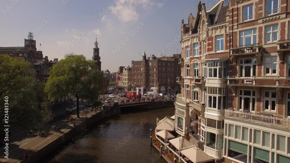 Aerial. Tour boats on water channel in Amsterdam. Camera moving up. 4K