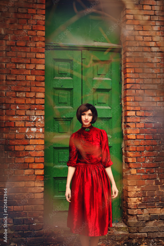Girl in red retro dress on a background of vintage wooden door. Girl in red retro dress on a background of vintage wooden door.