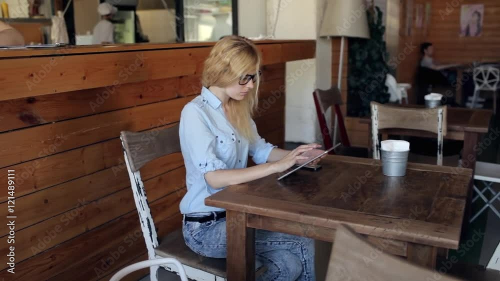 Young Woman Using Digital Tablet at Cafe Young Woman Using Digital Tablet at Cafe