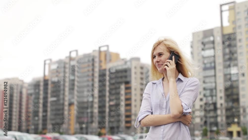 Girl Talking on the Phone While Standing on Street Parking on the Background of Houses Girl Talking on the Phone While Standing on Street Parking on the Background of Houses