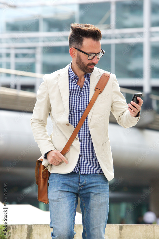 Mature guy man walking outdoors and using mobile phone Mature guy man walking outdoors and using mobile phone