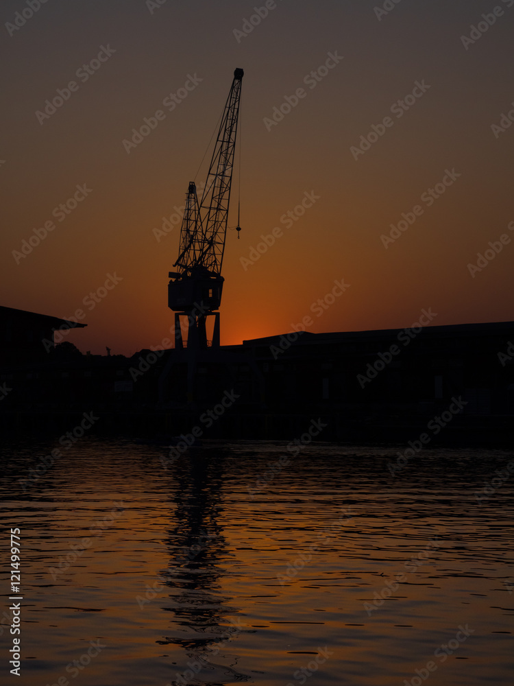 Silhouette eines Krans im Hafen von Lübeck, Deutschland, bei Sonnenuntergang