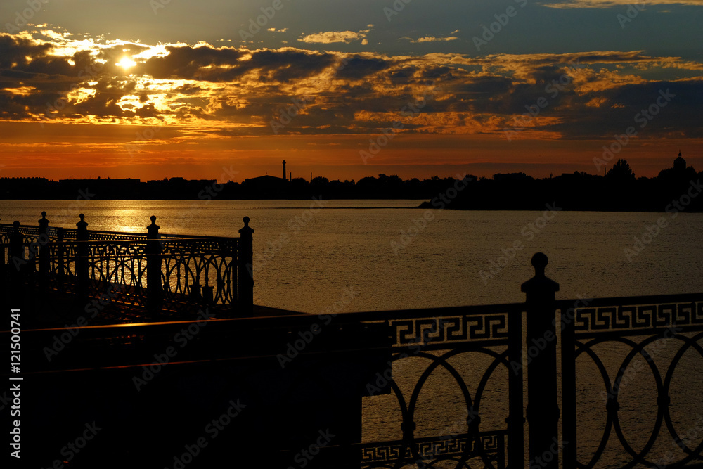 Beautiful sunset on the river metal fence of embanlment silhouette
