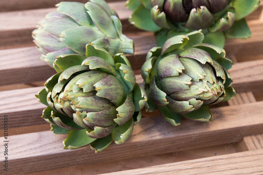 Obraz premium Ripe organic artichokes on the rustic wooden lattice