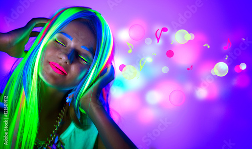 Beautiful young woman in neon light. Disco girl with fluorescent make-up photo