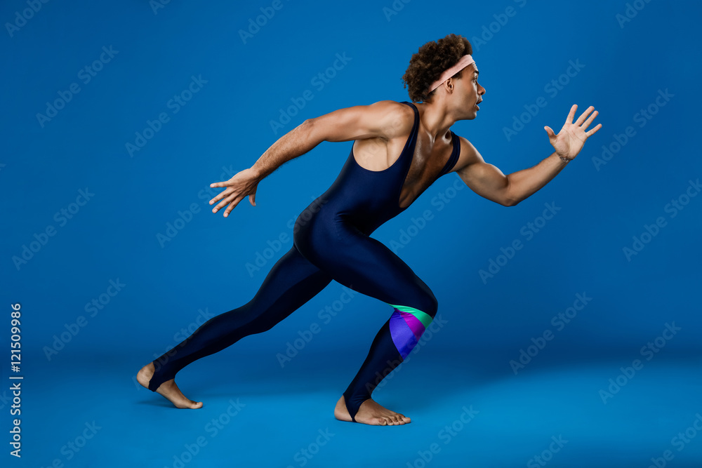 Sportive african man pretending run over blue background.