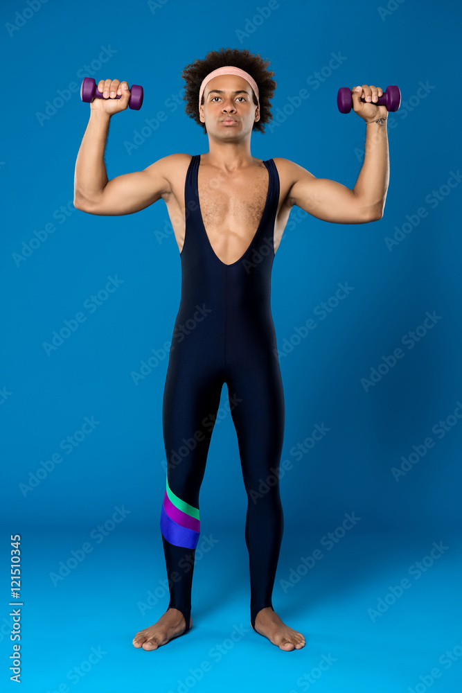 Sportive african man training with dumbbells over blue background. Sportive african man training with dumbbells over blue background.