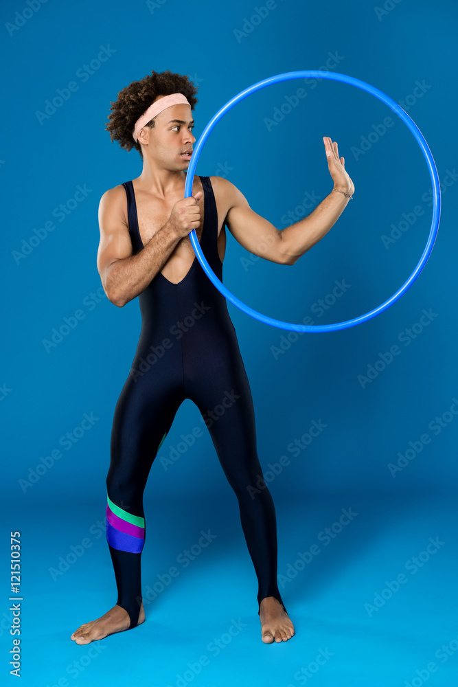 Sportive african man posing with hoop over blue background. Sportive african man posing with hoop over blue background.
