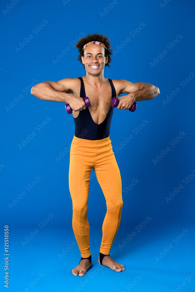 Sportive african man training with dumbbells over blue background.