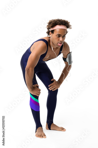 Sportive african man resting after running over white background.