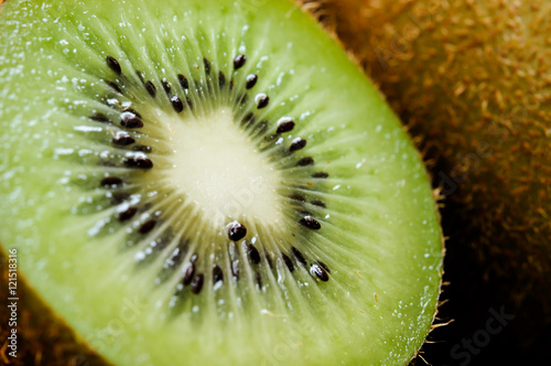 Some fresh Kiwi Fruits (selective focus) on an old wooden table, half of kiwi