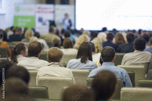 Female Host Speaking in Front of the Large Audience During Business Conference