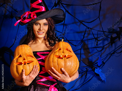 Happy halloween witch girl keeps orange pumpkin. Girl witch keeps halloween Jack OLanten. photo