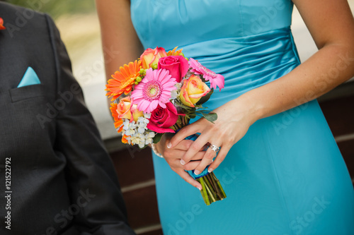 Bridesmaid and groomsman walking down the aisle with colorful bo photo