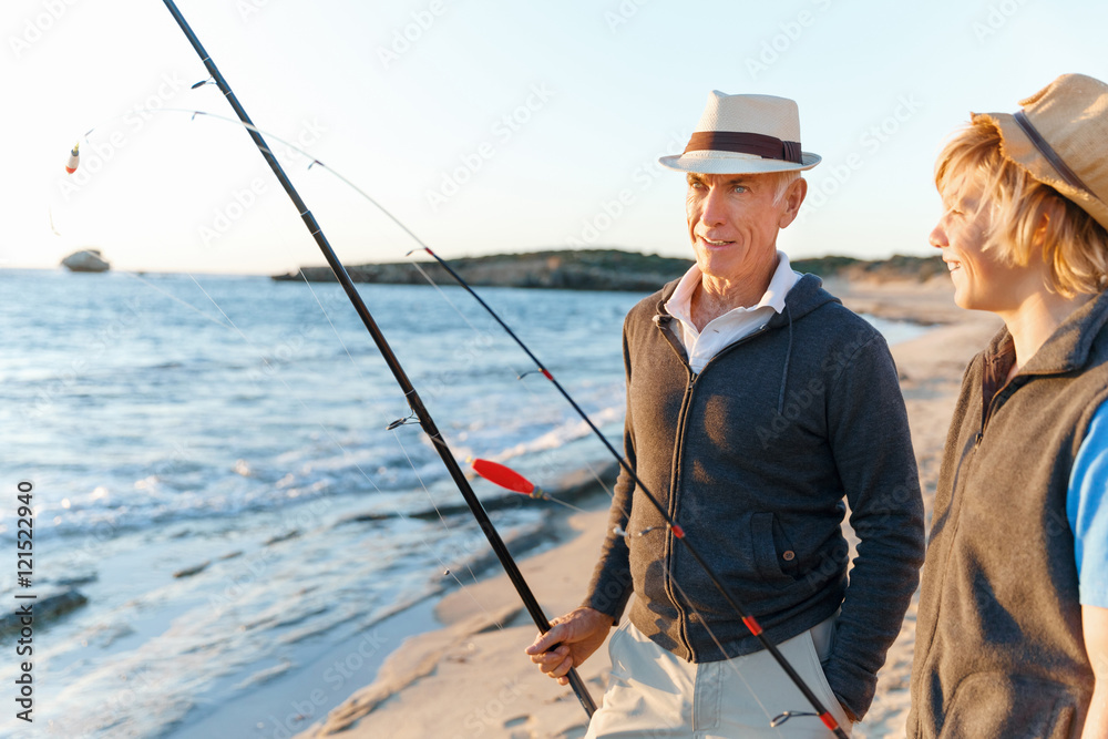 Obraz premium Senior man fishing with his grandson