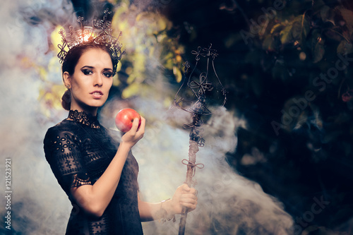 Evil Queen with Poisoned  Apple in Misty Forest photo