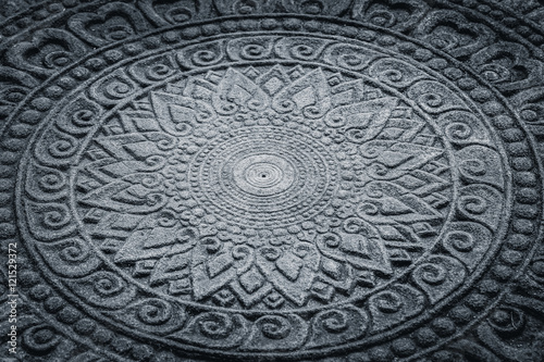 dark stone carving in Thai art pattern for background.