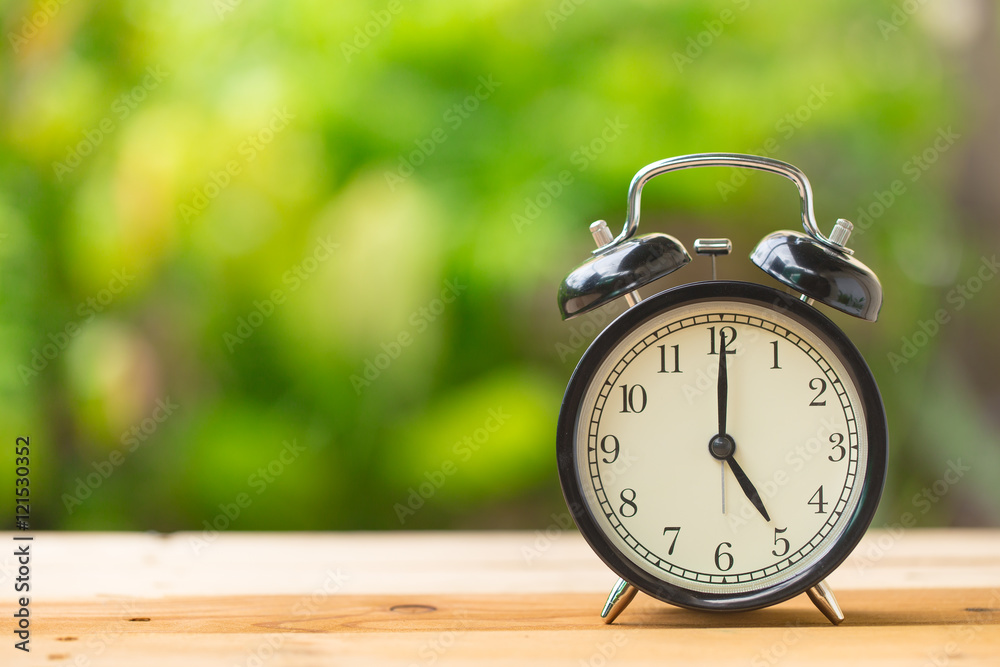 clock on wood table in the green garden time at 5 o'clock clock on wood table in the green garden time at 5 o'clock