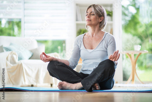a beautiful middle aged  woman in the lotus position in her livi photo